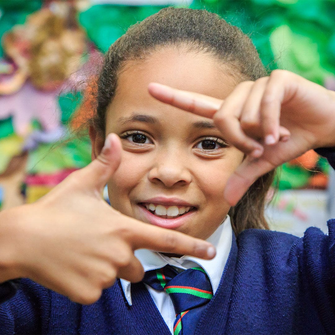 A girl pretending to take a picture with her hands